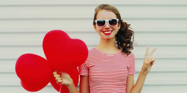 Portret Uśmiechniętej Młodej Kobiety Bandą Czerwonych Balonów Kształcie Serca Białym — Zdjęcie stockowe