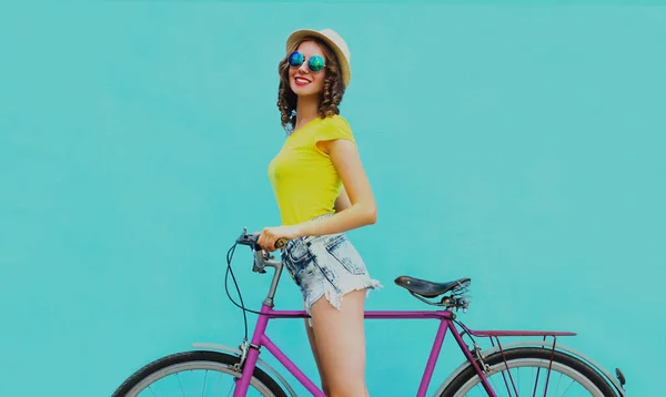 幸せな若いです笑顔の女性で自転車で青い背景 — ストック写真