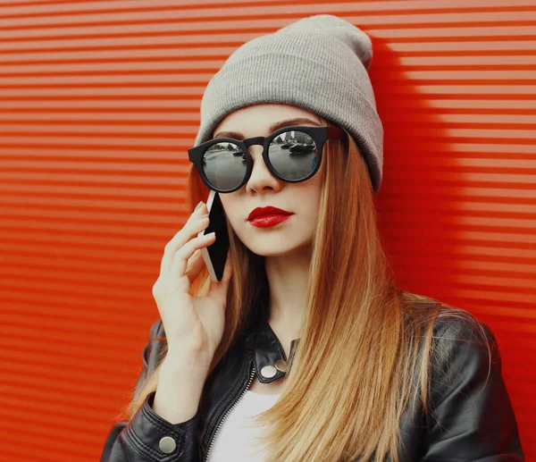 現代の若い女性の肖像は 赤い背景にスマートフォンを呼び出します — ストック写真