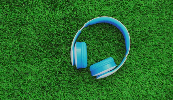 Close up blue wireless headphones on a green background, top view