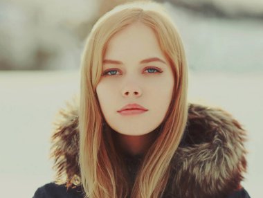 Portrait close up of beautiful young blonde woman outdoors