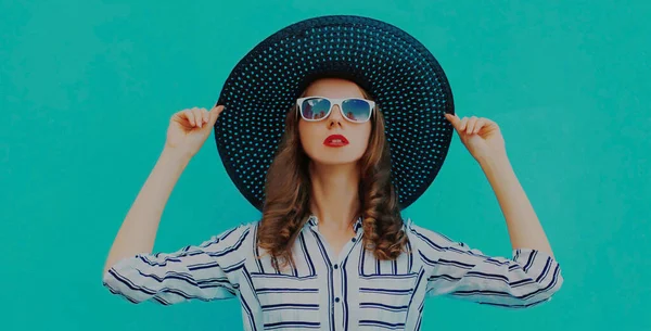 黒丸夏の帽子をかぶった美しい若い女性の肖像 青の背景に白いストライプのシャツ — ストック写真