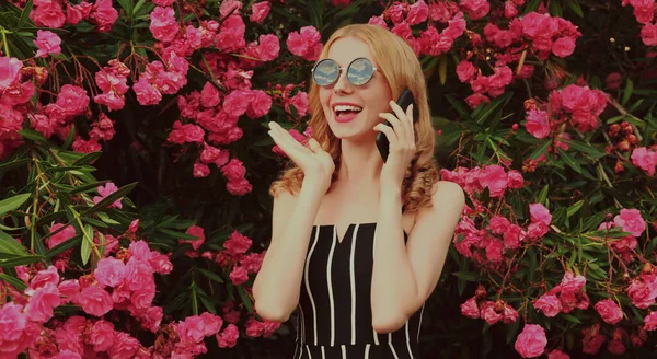 Portrét Krásné Překvapené Potěšené Ženy Volá Smartphone Růžové Květy Pozadí — Stock fotografie