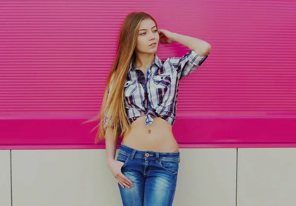 ピンクの背景にシャツを着た長髪の若い女性の肖像 — ストック写真