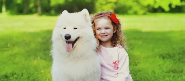 Küçük Kız Beyaz Samoed Köpek Yaz Parkında Çimlerin Üzerinde Birlikte — Stok fotoğraf