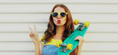 Beyaz arka planda yeşil kaykaylı genç bir kadının portresi.