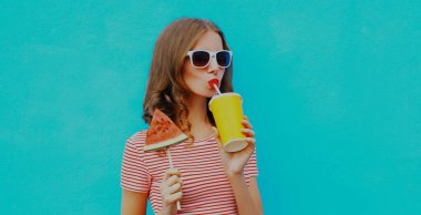 Mavi arka planda dondurmalı meyve suyu içen bir karpuz dilimi.