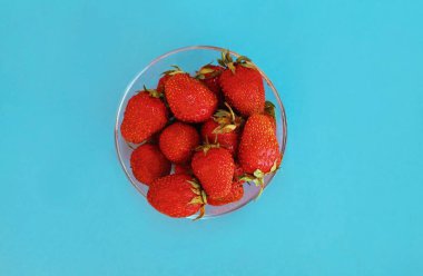 Mavi arka planda taze çilek kasesini kapat.