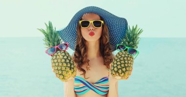 Sahilde hasır şapka takan iki komik ananaslı havalı kız.