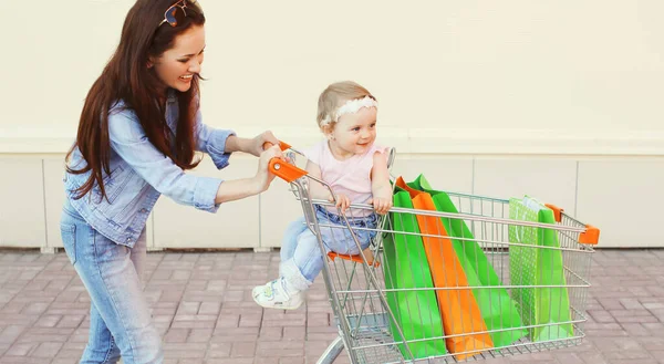 Boldog Mosolygós Anya Gyermek Bevásárló Táskák Bevásárlókocsi Séta Városban — Stock Fotó