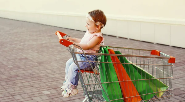 在城市里 坐在推车里的购物袋里的快乐婴儿 — 图库照片