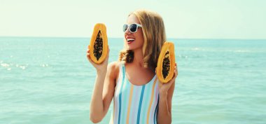 Sahilde gülümseyen mutlu genç bir kadının yaz portresi.