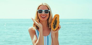 Sahilde gülümseyen mutlu genç bir kadının yaz portresi.