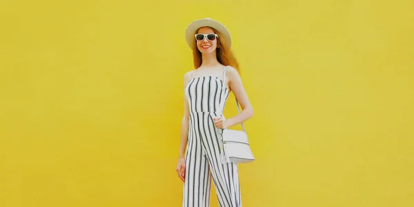 美丽的年轻女子 戴着夏季圆圆的草帽 身穿黄色背景的白色条纹连衣裙 面带微笑 — 图库照片