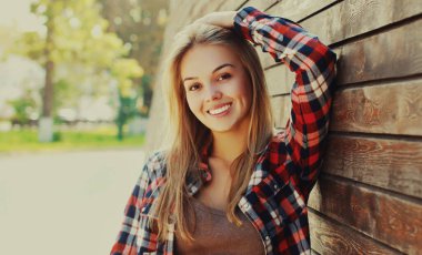 Şehirde sıradan, mutlu, gülümseyen sarışın bir kadının portresi.