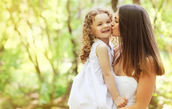 Happy mother kissing daughter