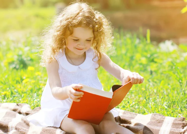 Kleines Mädchen liest ein Buch im Freien — Stockfoto