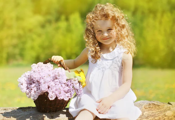Yazın güneşli portre sevimli kıvırcık kız çiçek bas ile — Stok fotoğraf
