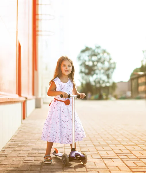 开朗很酷的小快乐的女孩穿着在滑板车上 — 图库照片