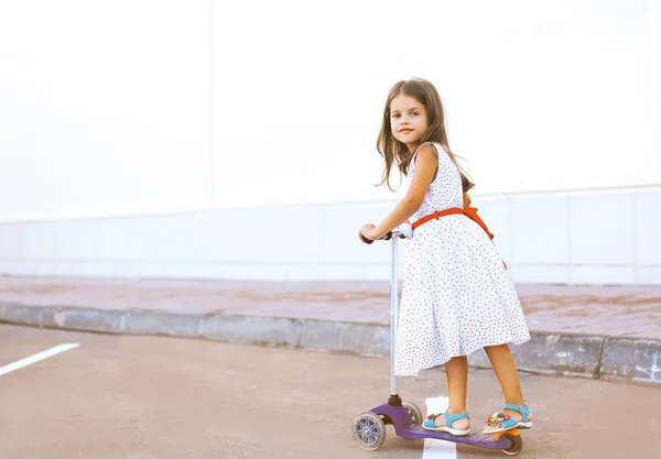 Menina bonito montando uma scooter se divertindo — Fotografia de Stock