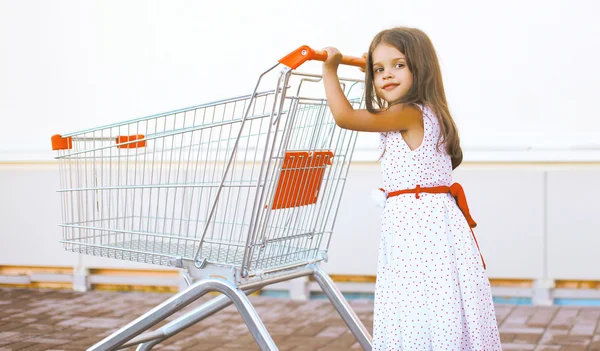 Neşeli küçük kız alışveriş sepeti ile — Stok fotoğraf