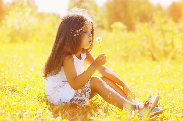 Kis gyerek fúj pitypang, napsütéses nyári nap — Stock Fotó