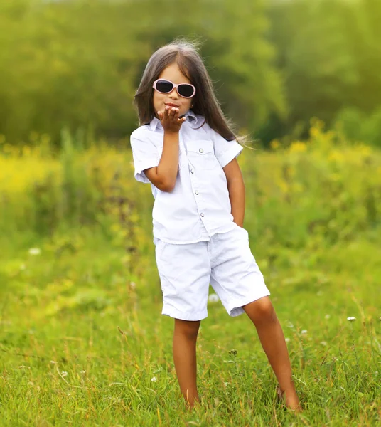 Стильна дівчинка в сонцезахисних окулярах позує на відкритому повітрі — стокове фото