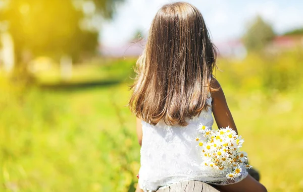 Summer day, silhouette little girl with flowers enjoying nature — Stock Photo, Image