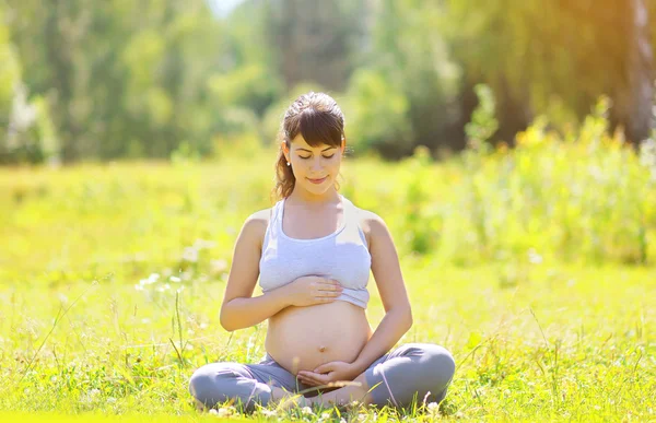 Zwangere mooie vrouw yoga buiten — Stockfoto