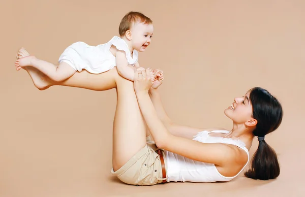 Madre sosteniendo bebé, diversión, ejercicio, ocio - concepto — Foto de Stock