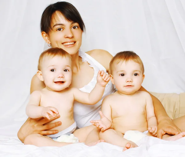 Gemelos positivos y mamá en la cama — Foto de Stock