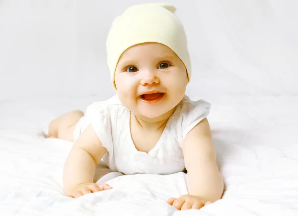 Bebê bonito em chapéu na cama se divertindo — Fotografia de Stock