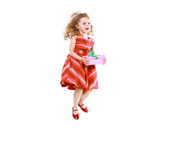 Cheerful little girl jumping with a gift — Stock Photo, Image