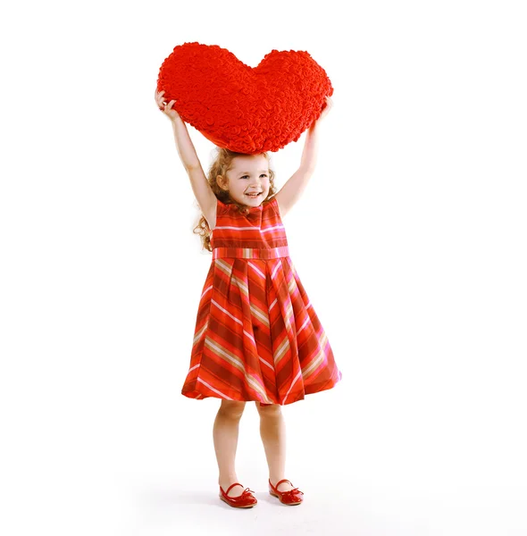 Neşeli küçük sevimli kıvırcık bir kalp tutan elbiseli kız — Stok fotoğraf