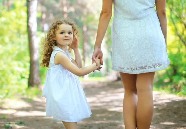 Menina encaracolado bonito andando com a mãe — Fotografia de Stock