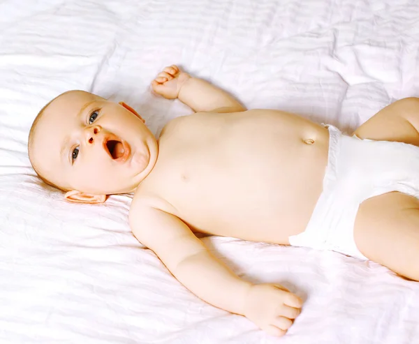 Pequeno bebê bonito bocejando na cama — Fotografia de Stock
