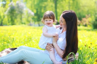 mutlu anne ve bebek yaz aylarında parktaki eğleniyor