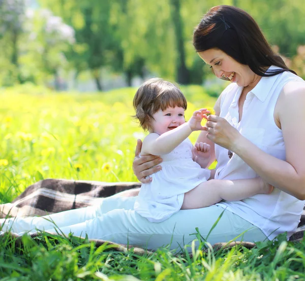 Glad glad mamma och baby spelar i sommar park — Stockfoto