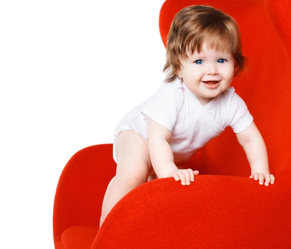 Vrolijke gelukkig baby spelen op rode stoel — Stockfoto