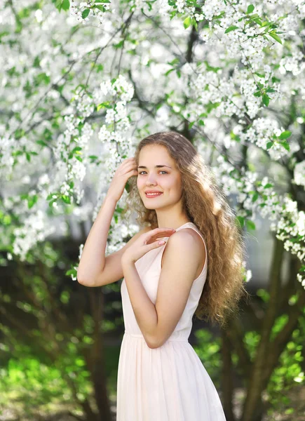 Söt flicka leende i den blommande trädgården — Stockfoto