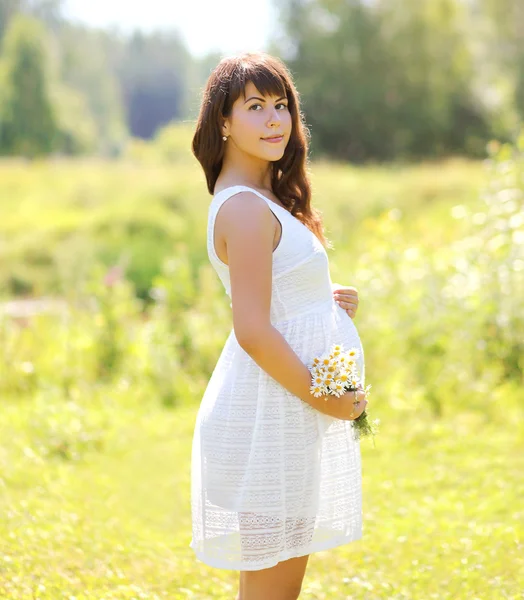 Güzel hamile kadın ve yaz günü çiçek — Stok fotoğraf