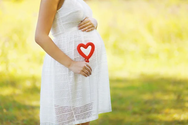 Embarazo, maternidad, familia - concepto, mujer embarazada y corazón —  Fotos de Stock