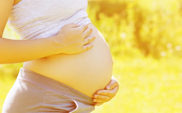 Terhesség, a várandós anya, a nyári napsütésben — Stock Fotó