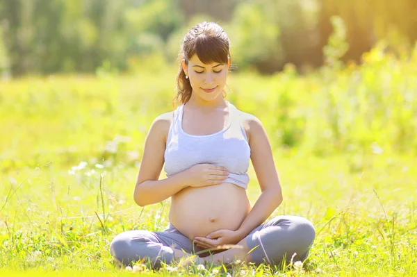 Беременная женщина йога на открытом воздухе — стоковое фото