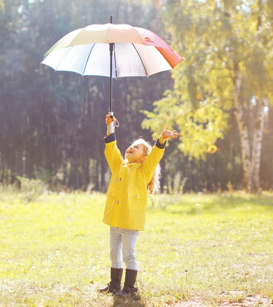 Positive child with colorful umbrella having fun in autumn day — Stock Photo, Image