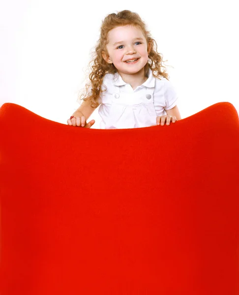 Positive cheerful little girl showing on blank red space — Stock Photo, Image