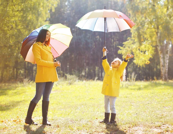 Familia con paraguas colorido divertirse disfrutando del tiempo en aut —  Fotos de Stock