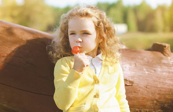 Criança com doces se divertindo ao ar livre — Fotografia de Stock