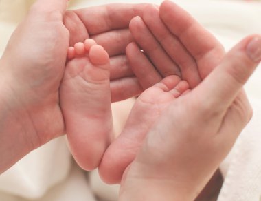 Anne bebek bacakları tutuyor