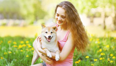 Happy girl and dog in summer sunny park clipart